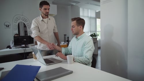 Colleagues Collaborating on a Laptop in an Office