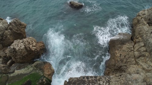 Meer mit Wellen brechen und schäumen an einem felsigen Strand