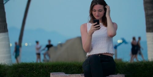 Woman Texting with Smartphone on the Beach