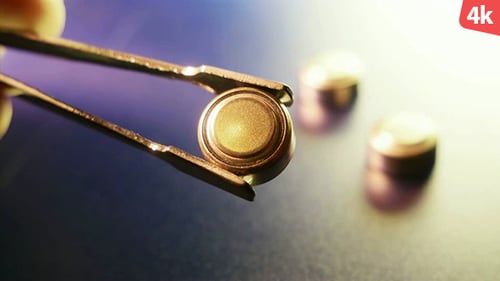 Tweezers Hold Small Golden Disc Battery Cell