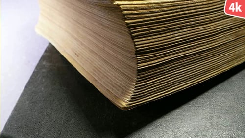 Close-Up of an Aged Thick Book on Dark Surface