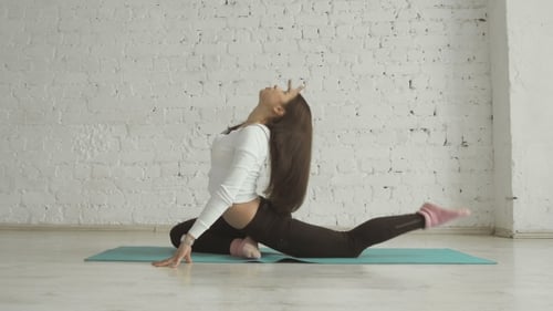 Woman Practices Yoga Pose on Blue Mat