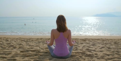 Young Woman Meditate on the Beach