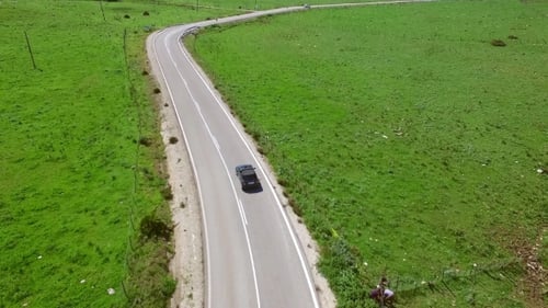 Car Driving Along a Winding Rural Road