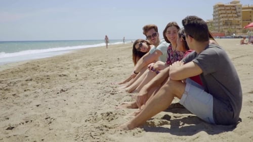 Group Of Trendy Young Friends Sitting On a Beach