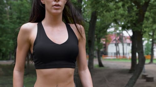 Attractive, Slim Brunette Doing Exercises In The Park