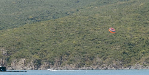 Touristen segeln auf dem Fallschirm über dem Meer