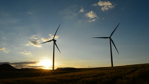 Wind Turbines Silhouetted on Hill at Sunrise or Sunset