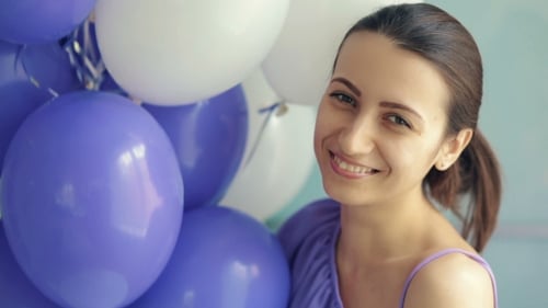 Happy Woman with Balloons Smiling and Laughing Indoors