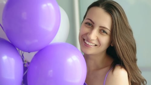 Smiling Woman with Purple Balloons