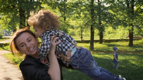 Family Values. Sister Or Mother Playing With a Little Boy. Sunny Day In The Park.