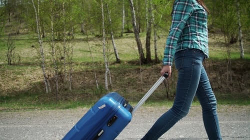 Garota vai na estrada com uma mala