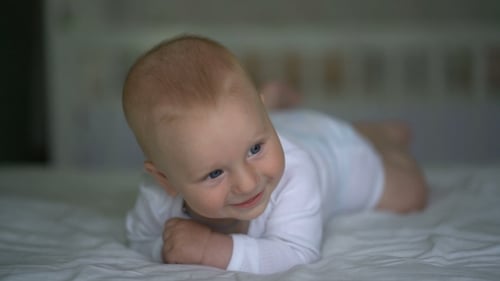 Cute Baby Smiling on White Blanket, Close Up