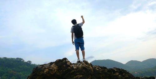 Man With Backpack Reaches Mountain Top