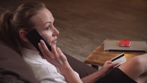 Woman Talking on Phone, Holding Credit Card