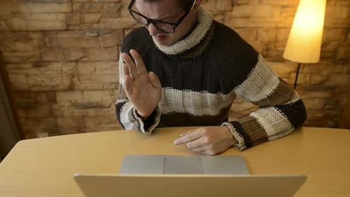 Frustrated Young Adult Gesturing at Laptop Computer