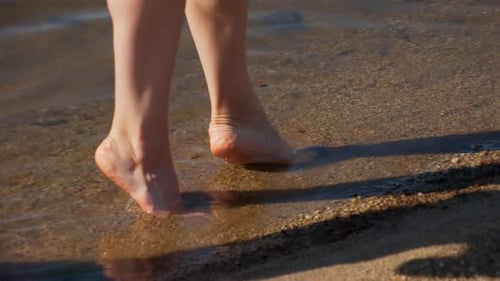 Woman Walks Barefoot on Sandy Beach Shoreline