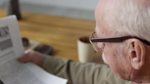 Senior Man Reading Newspaper Close Up