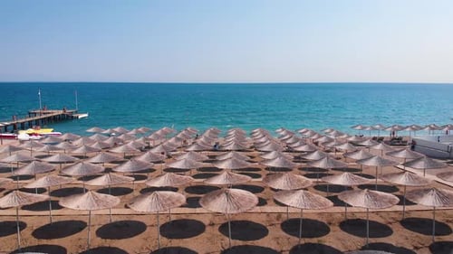 Flight Over the Beach with Umbrellas Towards the Pool in a Luxury Hotel