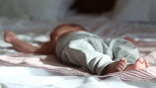 Bebé recién nacido acostado en una cama