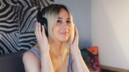 Young Woman Listens Music Wearing Headphones Indoors