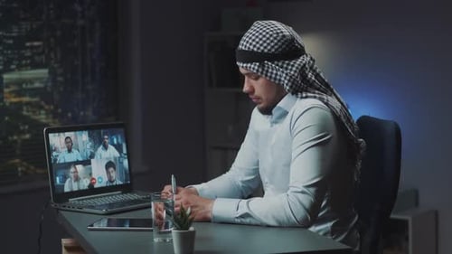 Man Wearing Headscarf in Virtual Meeting at Night