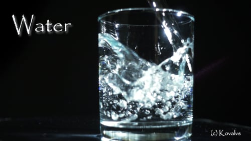 Water Being Poured into Clear Glass in Slow Motion