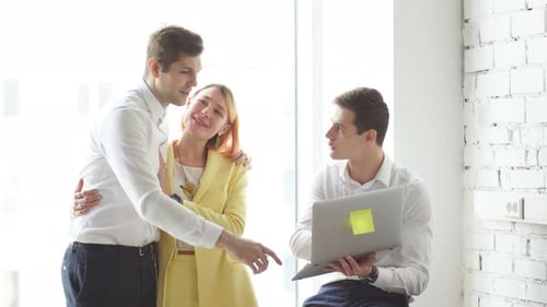 Young Office Colleagues Are Working on a Computer While Discussing Online Project