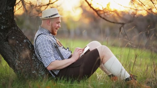 Stylish Young Man In The Park With Tablet In Hands.
