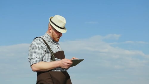 Colorful Young Man Uses a Digital Tablet.