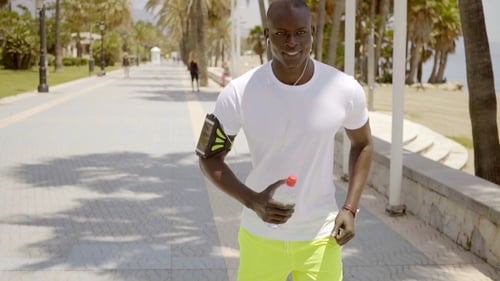 Man Jogging on Tropical Beach Promenade