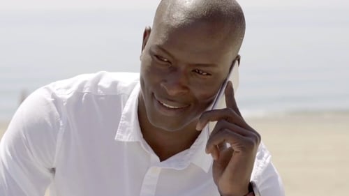 Man Talking on Phone at Sunny Beach