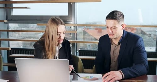 Man and a Woman Discussing Work in the Brightly Lit Modern Office. Concerned Male and Female Working