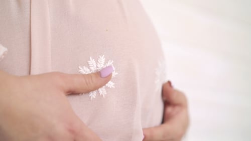Pregnant Woman Holds Her Baby Bump with Love