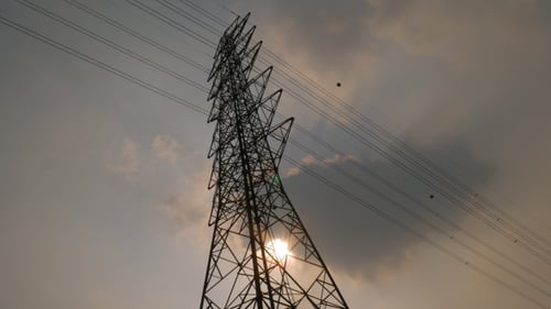 Electrical Tower Silhouette Against Cloudy Sunset Sky