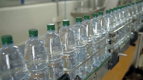 Water Bottles Moving Along Conveyor Belt in Factory