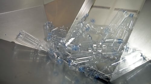Plastic Bottles Moving on Conveyor Belt at Recycling Plant