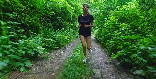 Woman Jogging Along a Forest Trail