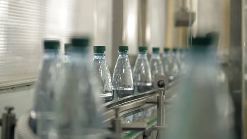 Water Bottles Moving Along Conveyor Belt in Factory