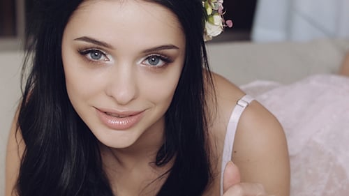 Sexy Mädchen mit Blumen auf dem Bett