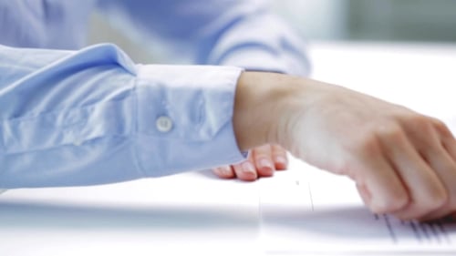 Person Signing Document With Pen In Office