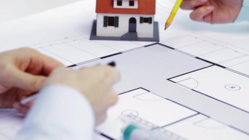 Architects Reviewing Blueprint with Model House