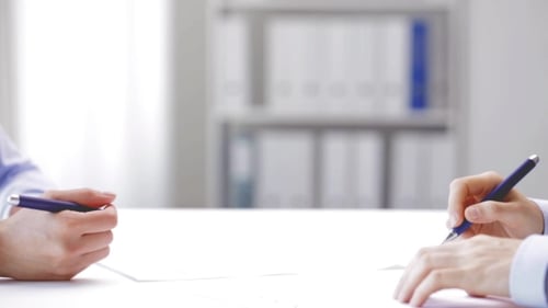Business Meeting and Agreement Signing in Modern Office