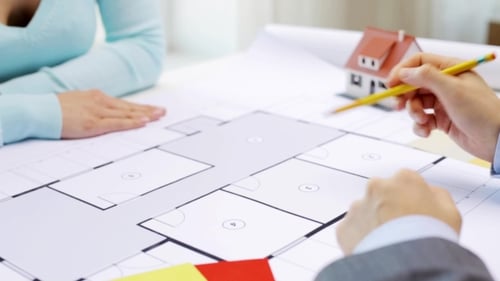 People Reviewing Architectural Plans with Pencil