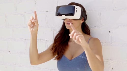 Woman Using Virtual Reality Headset Against Brick Wall