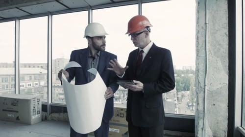 Architects Reviewing Blueprints in a Building Under Construction