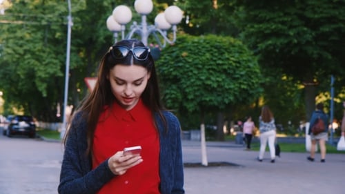 Attractive Woman Walking Down The Street, Enjoying Smartphone