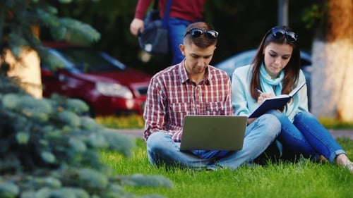 Students Man And Woman Working With a Laptop In The Park