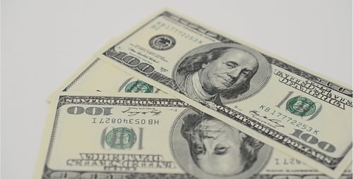 Stacking One Hundred Dollar Bills on White Surface