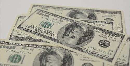 Stacking One Hundred Dollar Bills on White Surface